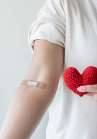 Blood donation concept. Give blood save up to three lives. Woman arm with the bandage plaster showing as a blood donation volunteer.