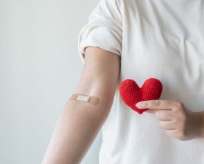 Blood donation concept. Give blood save up to three lives. Woman arm with the bandage plaster showing as a blood donation volunteer.