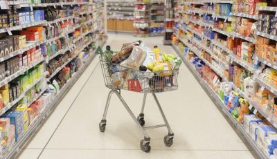 Full shopping cart in supermarket aisle