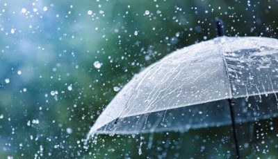 Transparent umbrella under heavy rain against water drops splash background. Rainy weather concept.