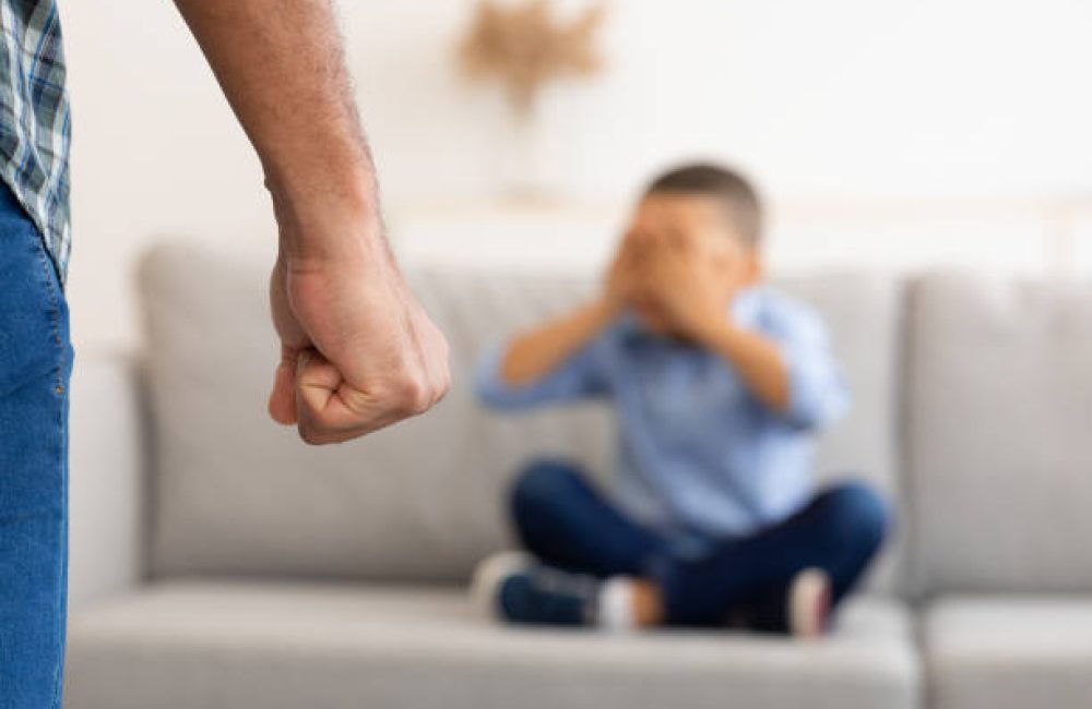 Child Abuse. Unrecognizable Black Father Clenching Fist Ready To Hit Scared Little Son Treatening Boy In Living Room At Home. Domestic Violence On Kid. Cropped, Selective Focus On Male Arm